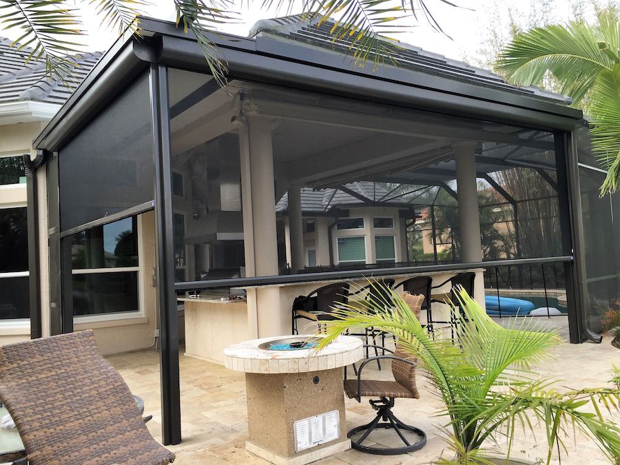 Outdoor entertainment area with outdoor shades and an outdoor bar